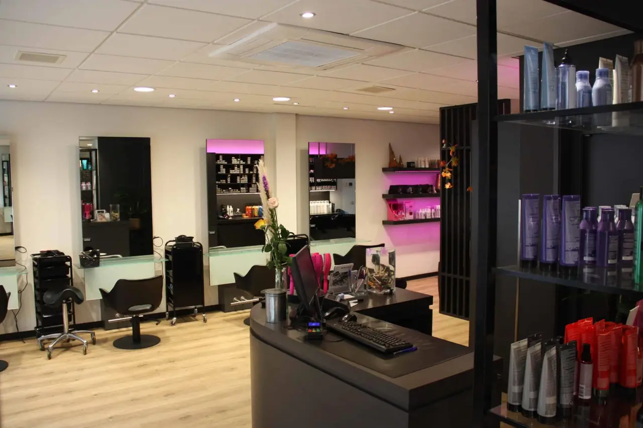 Professionele kapper in Tholen die persoonlijk kapseladvies geeft aan een klant in de kapsalon